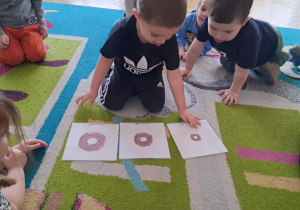 Chłopiec układa obrazki według instrukcji nauczyciela