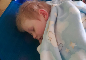 Chłopiec odpoczywa na leżaku po obiedzie