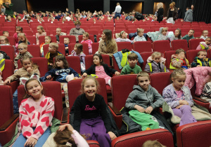 Dzieci siedzące na fotelach w teatrze