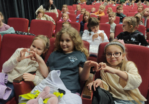 Dzieci siedzące na fotelach w teatrze