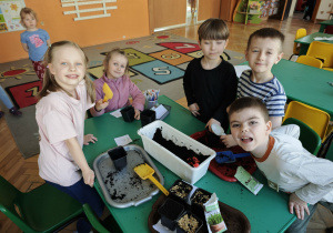 Dzieci sieją owies w doniczkach