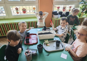 Dzieci sieją owies przy stole