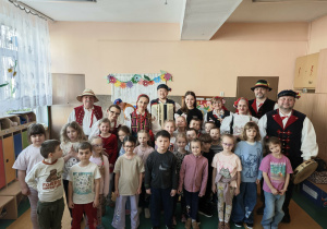 Dzieci razem z paniami i panami przebranymi w stroje ludowe