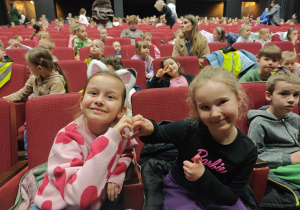 Dzieci siedzące na fotelach w teatrze