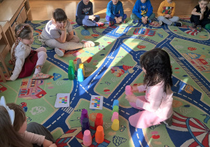 Dzieci uczestniczą w zajęciach z wykorzystaniem kolorowych kubeczków