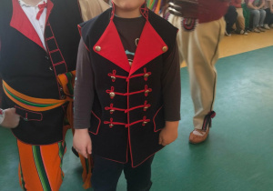 Chłopiec ubrany w strój ludowy pozuje do zdjęcia