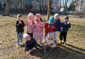 Dzieci uśmiechają się do zdjęcia na tle naszego placu zabaw