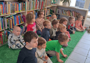 Dzieci słuchają pani bibliotekarki która mówi w jaki sposób szanujemy książki