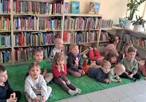 Dzieci słuchają pani bibliotekarki która mówi w jaki sposób szanujemy książki