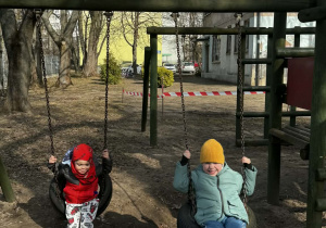 Chłopcy huśtają się na huśtawce