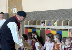 Dzieci oglądają tradycyjny instrument perkusyjny