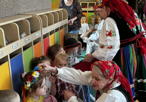 Dzieci przymierzają tradycyjne ludowe nakrycia głowy