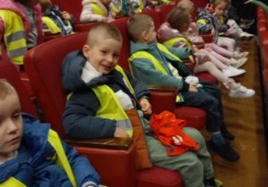 dzieci siedzą na siedzeniach w teatrze