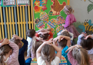 Dziewczynka przelicza jajka wielkanocne wykonane przez dzieci.