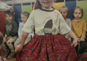 Dziewczynka prezentuje spódnicę i wianek krakowski.