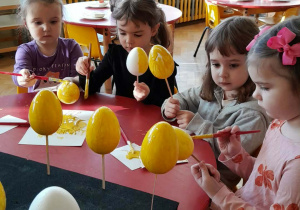 Dzieci malują jajka.