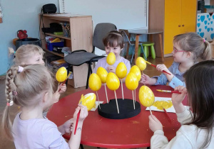 Dzieci malują jajka.