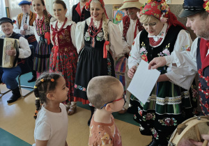 Grupa pań i panów ubranych w stroje ludowe