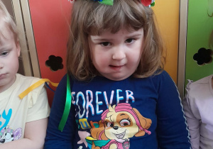 Dziewczynka ma na głowie wianek