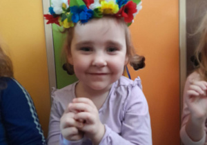 Dziewczynka ma na głowie wianek