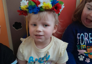 Dziewczynka ma na głowie wianek