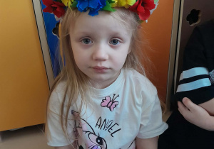 Dziewczynka ma na głowie wianek