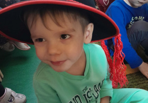 Chłopiec ma na głowie założony kapelusz