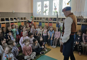 Pan z zespołu pokazuje instrument ludowy