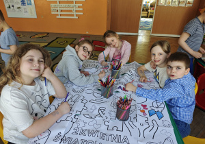 Dzieci kolorują dużą kolorowankę