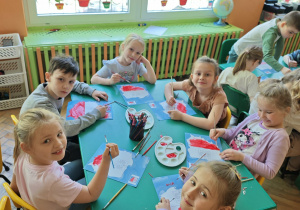 Dzieci malują czerwona farbą