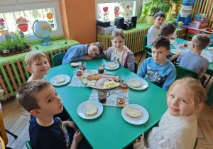 Dzieci siedzą przy stole przy śniadaniu