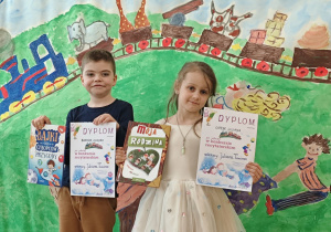 Chłopiec i dziewczynka stojący z dyplomem