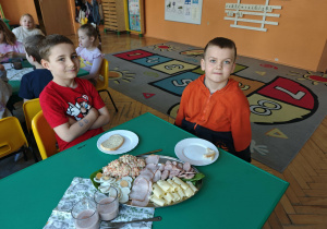 Dwóch chłopców siedzących przy stole w czasie śniadania