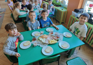 Czterech chłopców przy stole nakrytym w tematyce wielkanocnej