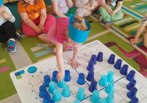 Dziecko wypełnia kubeczkiem kształt serca