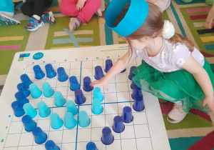 Dziewczynka wypełnia kubeczkiem kształt serca