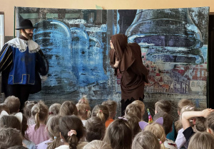 Dzieci siedzą podczas przedstawienia "Dzwonnik z Notre Dame"