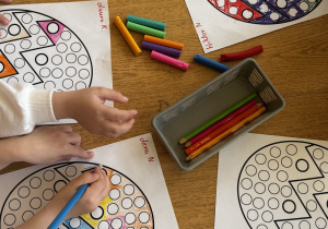 Dzieci wyklejają jajka wielkanocne plasteliną