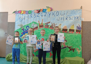 Dwie dziewczynki i dwóch chłopców pokazują swoje dyplomy