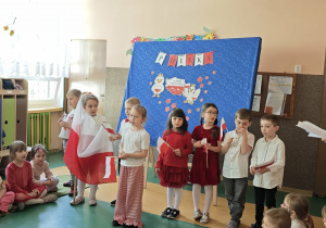 Dzieci stojące na tle dekoracji patriotycznej