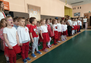 Dzieci śpiewają hymn podczas uroczystości .