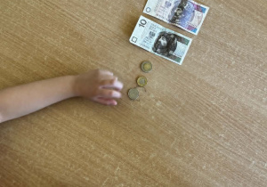 Dzieci układają monety i banknoty od najmniejszego nominału do największego