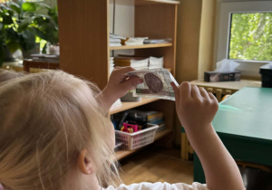 Dziewczynka ogląda banknoty pod światło