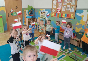 Dzieci bawią się przy użyciu flagi Polski