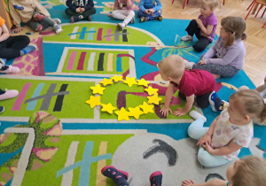 Dzieci układają gwiazdki w kształcie koła
