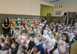 Dzieci siedzące na ławeczkach