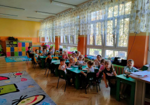 Dzieci w nowo wyremontowanej sali pracują przy stolikach