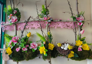 Dekoracja wisząca- okno wykonane z gałęzi brzozy przyozdobione wiosennymi kwiatami