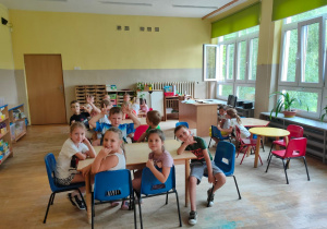 Dzieci siedzą przy stołach w nowo pomalowanej sali