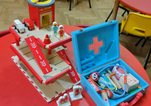 zabawkowy zestaw straży pożarnej i walizka z atrybutami lekarza